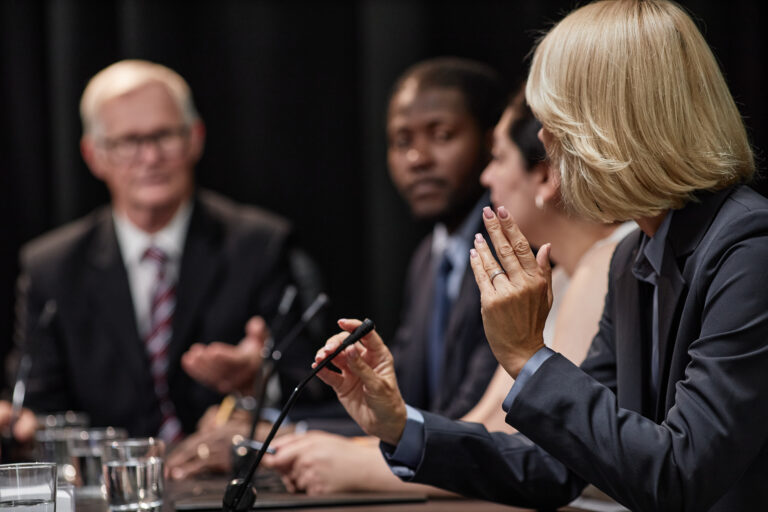 Panelists speaking, illustrating Managed care and pharmacy leaders discuss real-world experiences transitioning patients to Humira biosimilars at the AMCP Annual Meeting.