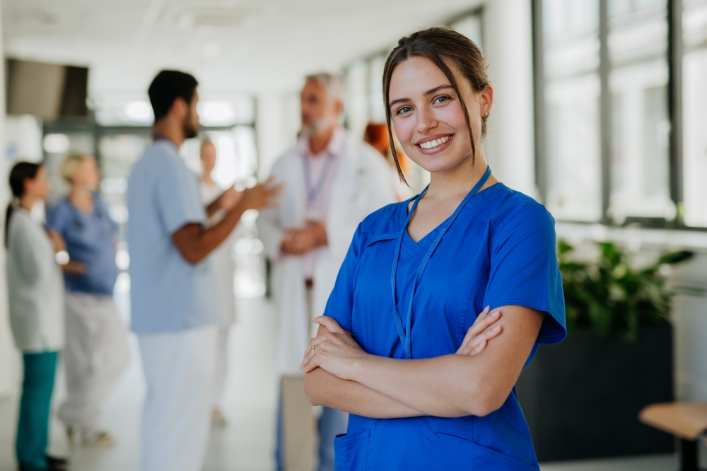 female pharmacist standing behind counter with her arms crossed