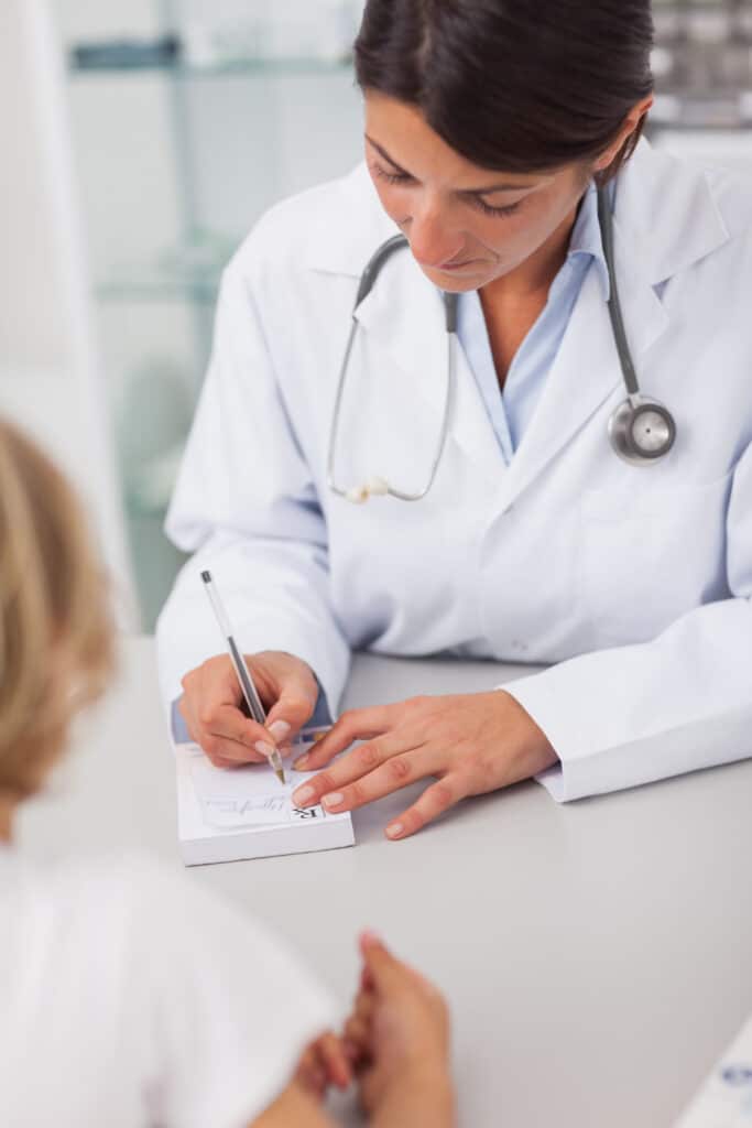 Pharmacist writes prescription patient.
